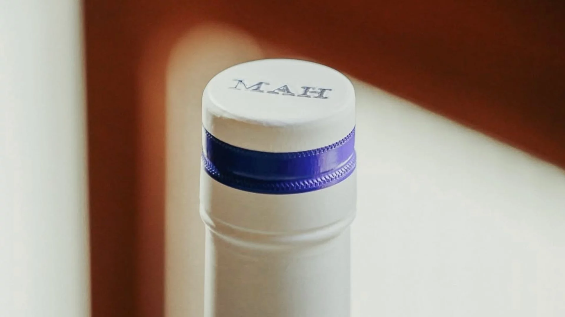 Capsule blanche et bague bleue de la bouteille MAH