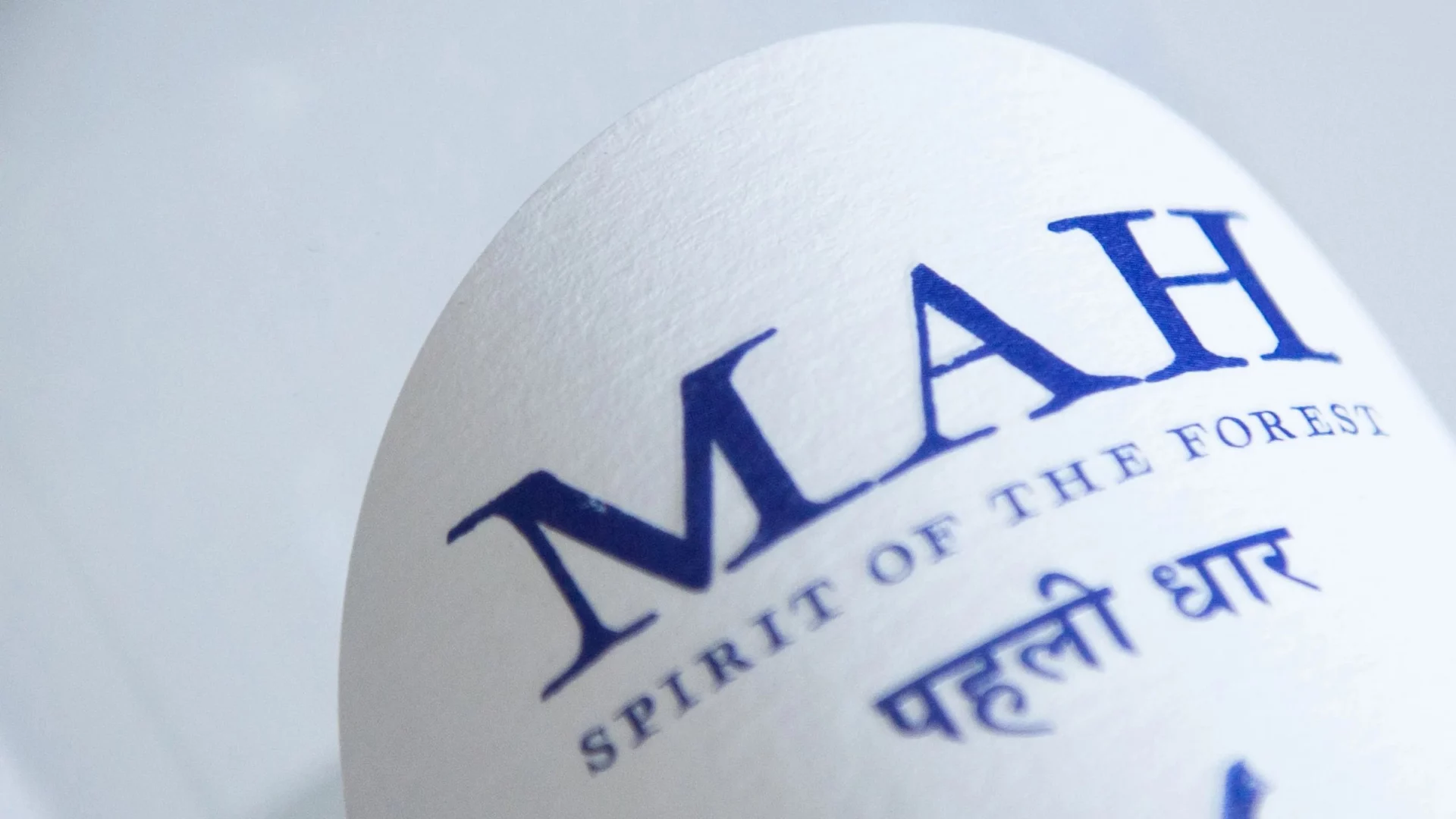 Gros plan sur l’étiquette MAH : logotype, « Spirit of the Forest » et inscription devanagari
