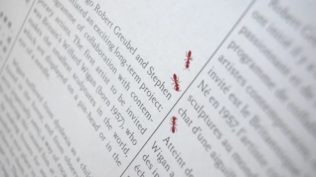 Texte du journal avec des fourmis rouges en marge